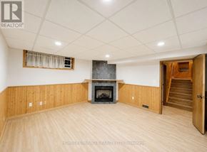 Kitchener apartment for rent - A living room with wood paneling and a fireplace.