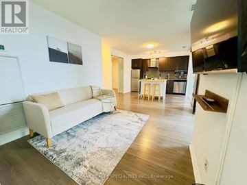 Toronto (Waterfront Communities) condo for rent - A living room with a couch and a rug in the middle of the room.