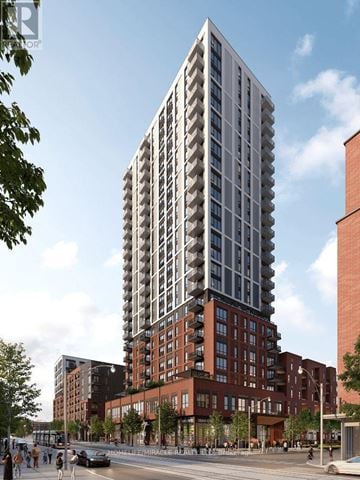 Toronto (Regent Park) condo for rent - A tall, modern building with many windows is the focal point of the image.