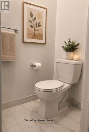 Toronto (Regent Park) condo for rent - A white toilet in a bathroom with a plant on the side.