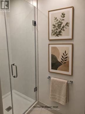 Toronto (Regent Park) condo for rent - A bathroom with a towel hanging on a rack and two pictures on the wall.