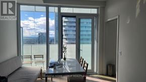 Mississauga (City Centre) condo for rent - A living room with a view of the city through large windows.