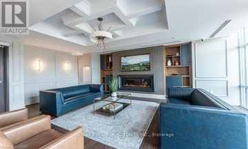 Hamilton (Waterdown) condo for rent - A living room with a blue couch and a fireplace.