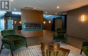 Hamilton (Waterdown) condo for rent - A living room with a fireplace and green chairs.