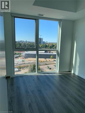 Kitchener condo for rent - A room with a view of a cityscape through a large window.