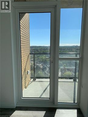 Kitchener condo for rent - A view from a window looking out to a balcony with a railing.