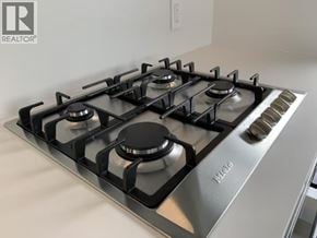 Vancouver apartment for rent - A modern gas stove with four burners and a stainless steel finish.