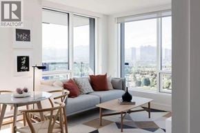 Vancouver apartment for rent - A living room with a grey couch, a white table, and a large window.