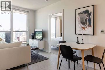 Vancouver apartment for rent - A living room with a white couch, a small table, and a painting on the wall.