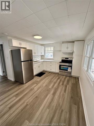 Wallaceburg apartment for rent - A kitchen with white cabinets and a stainless steel refrigerator.