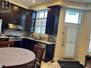 Markham (Cornell) townhouse for rent - A kitchen with dark brown cabinets and a round table with a white tablecloth.