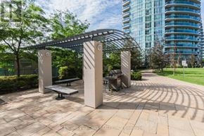 Mississauga (City Centre) condo for rent - A park bench is situated under a metal pergola.