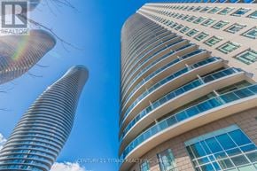 Mississauga (City Centre) condo for rent - A tall building with a curved design stands next to a cylindrical building.
