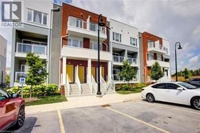 Kitchener townhouse for rent - A white car is parked in a parking lot in front of a building with a sign that says REALTOR.