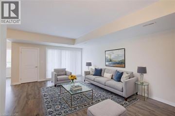Kitchener townhouse for rent - A living room with a grey couch, a glass coffee table, and a painting on the wall.