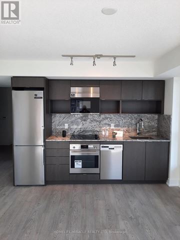 Toronto (Islington-City Centre West) condo for rent - A modern kitchen with dark wood cabinets and stainless steel appliances.