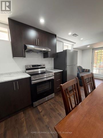Halton Hills (Georgetown) apartment for rent - A kitchen with dark wood cabinets and stainless steel appliances.