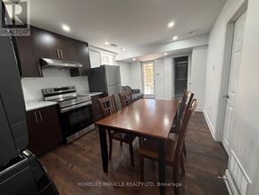 Halton Hills (Georgetown) apartment for rent - A kitchen with dark wood cabinets and a wooden table with chairs.