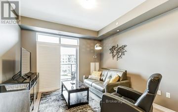 Hamilton (Lakeshore) condo for rent - A living room with a black leather couch and a coffee table.