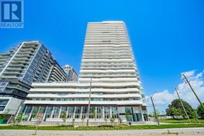 Pickering (Bay Ridges) condo for rent - A tall building with a glass facade stands in front of a smaller building.