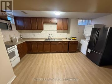 Toronto (Highland Creek) apartment for rent - A kitchen with wooden cabinets and a black refrigerator.