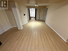 Toronto (Highland Creek) apartment for rent - A room with wooden flooring and white walls, with a door at the end of the hallway.