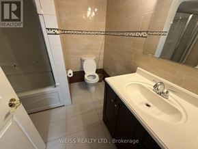 Toronto (Highland Creek) apartment for rent - A bathroom with a toilet, sink, and mirror.