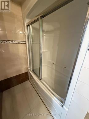 Toronto (Highland Creek) apartment for rent - A shower area with a glass door and tiled walls.