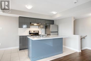 Ottawa townhouse for rent - A kitchen with a blue island and stainless steel appliances.