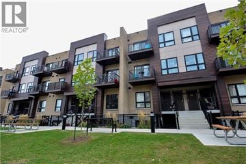 Kitchener townhouse for rent - Apartment complex with a tree in front of it.
