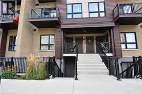 Kitchener townhouse for rent - A brown building with black railings and a black door.