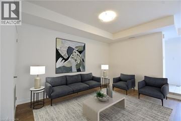 Kitchener townhouse for rent - A living room with a grey sofa, two chairs, a coffee table, and a painting on the wall.
