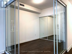 Toronto (Waterfront Communities) condo for rent - A room with glass walls and wooden floors.