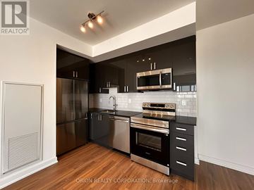 Pickering (Bay Ridges) condo for rent - A modern kitchen with stainless steel appliances and wooden flooring.