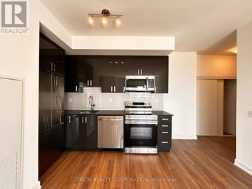 Pickering (Bay Ridges) condo for rent - A modern kitchen with black cabinets and stainless steel appliances.