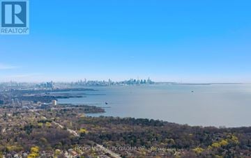 Mississauga (Clarkson) condo for rent - A cityscape with a body of water in the foreground and a clear blue sky above.