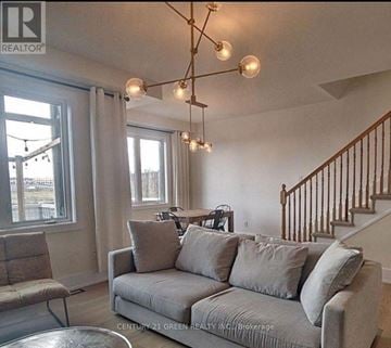 Ottawa townhouse for rent - A living room with a grey couch and a chandelier.
