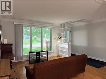 Waterloo apartment for rent - A living room with a brown couch and a wooden floor.
