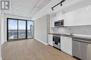 Toronto (Moss Park) condo for rent - A modern kitchen with white cabinets and stainless steel appliances.