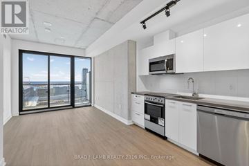 Toronto (Moss Park) condo for rent - A modern kitchen with white cabinets and stainless steel appliances.