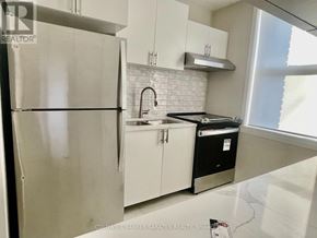 Ottawa apartment for rent - A kitchen with a refrigerator, sink, and cabinets.