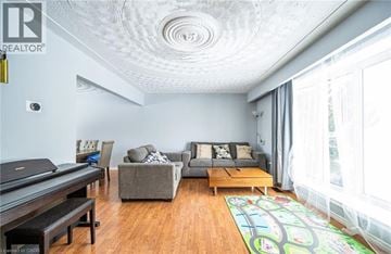 Kitchener apartment for rent - A living room with a grey couch, a coffee table, and a rug with a road design on it.