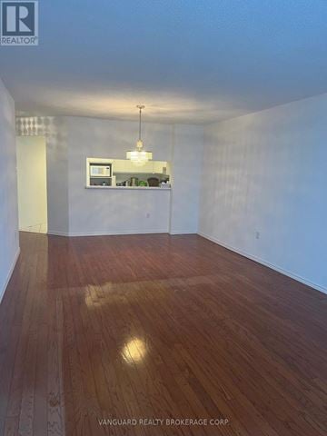 Vaughan (Brownridge) condo for rent - A room with wooden floors and a small kitchenette in the corner.
