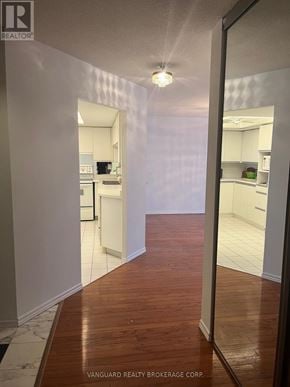 Vaughan (Brownridge) condo for rent - A hallway with a kitchen visible through the glass doors.