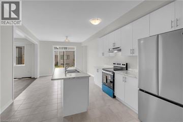 Brantford apartment for rent - A modern kitchen with white cabinets and a central island.