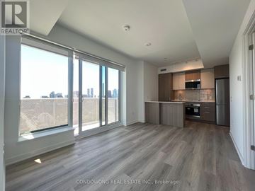 Toronto (Regent Park) condo for rent - A spacious living room with a kitchen area in the background.