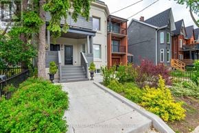 Toronto (Roncesvalles) multi-family for rent - A house with a front yard and a driveway.