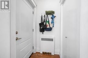 Toronto (Roncesvalles) multi-family for rent - A hallway with a coat rack and a white door.