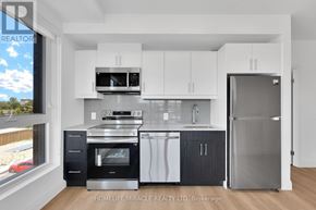 Kitchener condo for rent - A modern kitchen with white cabinets and stainless steel appliances.
