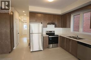 Hamilton townhouse for rent - A kitchen with a refrigerator, oven, and sink.